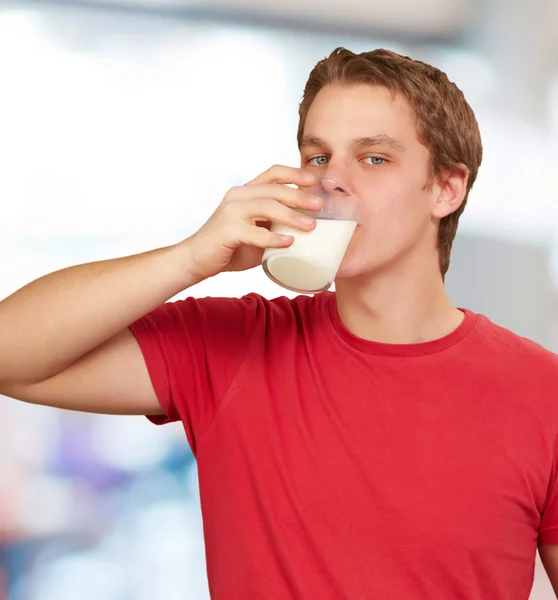 Retrato de jovem bebendo leite interior — Fotografia de Stock