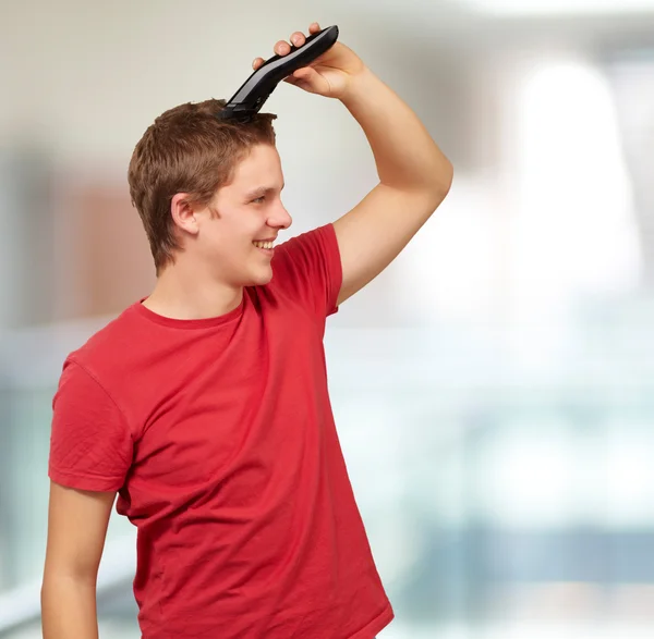 Porträtt av ung man klippa hans hår inomhus — Stockfoto