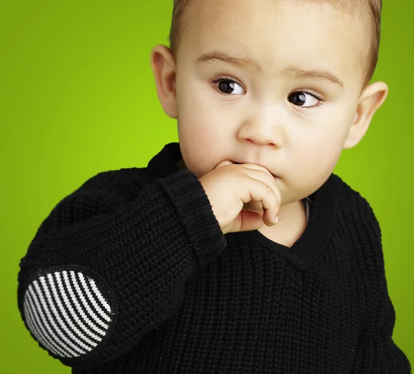Портрет очаровательного ребенка, думающего на зеленом фоне — стоковое фото