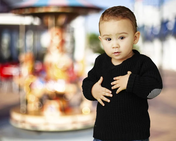 Portret adorable kid dotykając jego żołądek przed karuzela — Zdjęcie stockowe