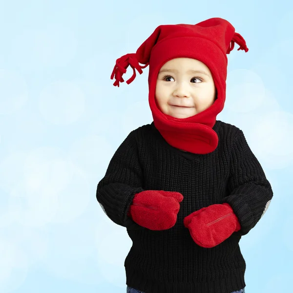 Ritratto di un adorabile bambino sorridente che indossa abiti invernali su uno sfondo blu — Foto Stock