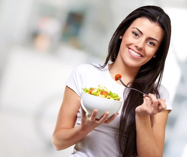 Портрет здоровой женщины, которая ест салат в помещении — стоковое фото