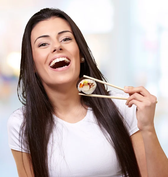 Portrait of young woman holding sushi indoor — Stock Photo, Image