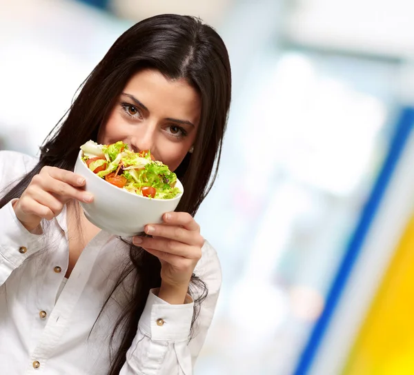 Retrato de mujer joven sosteniendo una ensalada fresca en el interior — Foto de Stock