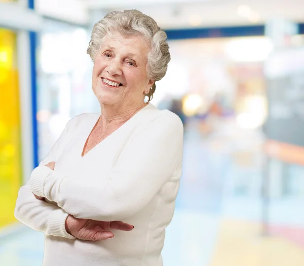 Portrait of senior woman smiling at a modern building — Stock Photo, Image