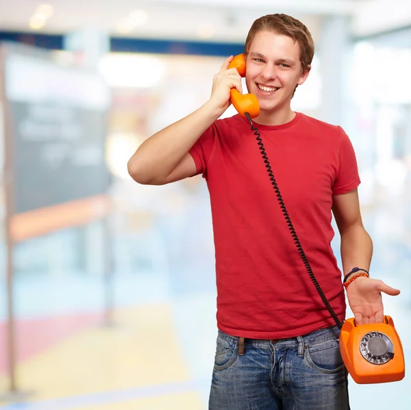Portrait of young man talking with vintage telephone indoor Stock Photo