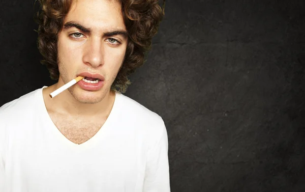 Ritratto di un fumatore triste contro un muro di grunge — Foto Stock