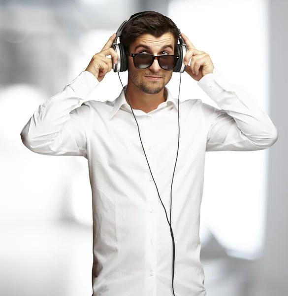 Portrait of young man listening to music using headphones indoor — Stock Photo, Image
