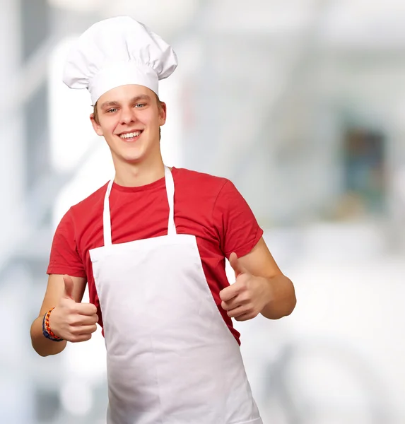 Retrato de un joven cocinero haciendo símbolo de éxito en interiores — Foto de Stock