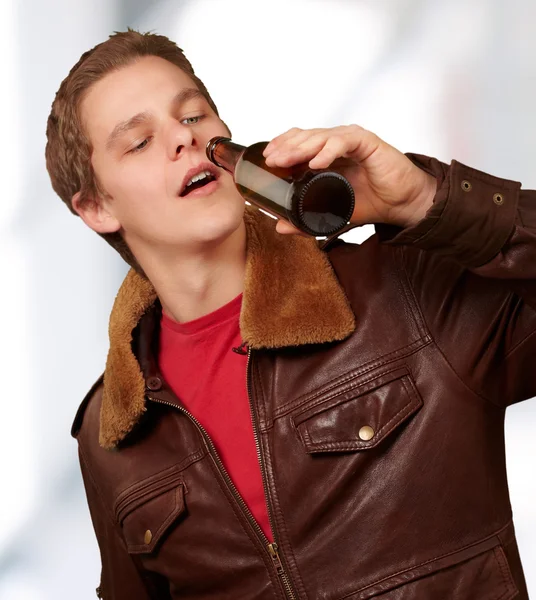 Porträt eines jungen Mannes, der drinnen Bier trinkt — Stockfoto