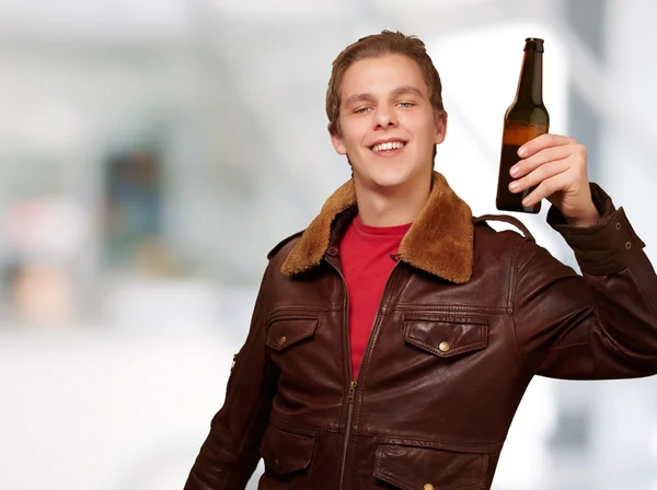 Retrato de un joven sosteniendo cerveza en el interior —  Fotos de Stock