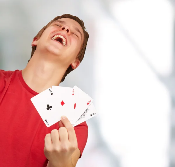 Portret van jonge man doen een winnaar gebaar spelen poker indoor — Stockfoto