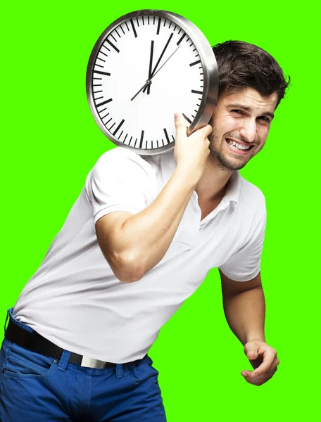 Retrato de um jovem bonito carregando um relógio contra um remo — Fotografia de Stock