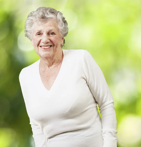 Симпатичная пожилая женщина улыбается на фоне природы — стоковое фото