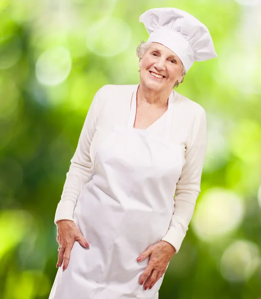 Portrét starší ženy cook usmívající se proti přírodě poza — Stock fotografie