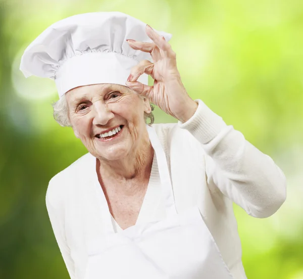 Femme âgée cuisinier faisant un excellent symbole contre un bac nature — Photo