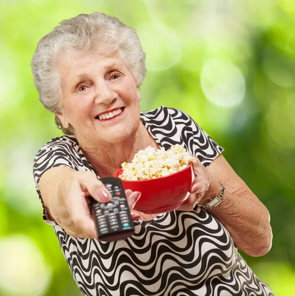 Portrait d'une femme âgée tenant un bol de maïs pop et changeant de chan — Photo