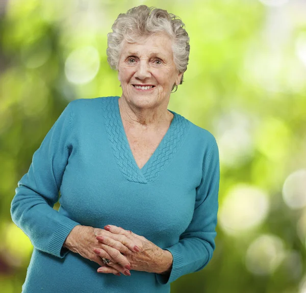 Portret van senior vrouw die lacht tegen een achtergrond van de natuur — Stockfoto