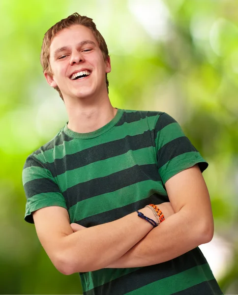 Portret van een jonge man die lacht tegen een achtergrond van de natuur — Stockfoto