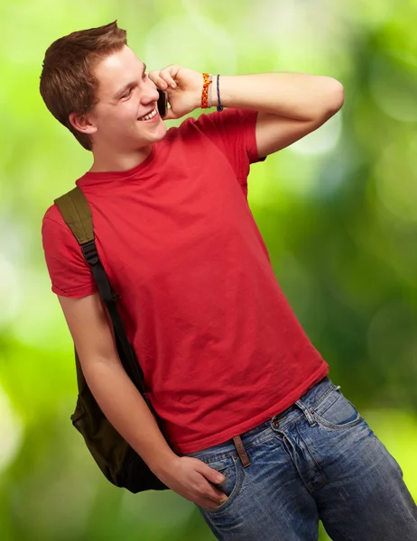Портрет молодого человека, разговаривающего по мобильному телефону с природой backgro — стоковое фото