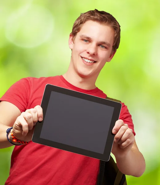 Porträtt av ung man hålla en digital tablett mot en natur — Stockfoto
