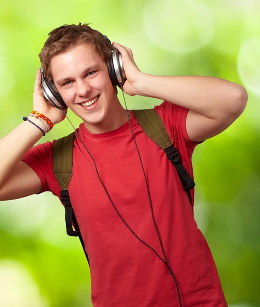 Retrato de jovem estudante alegre ouvindo música com headphon — Fotografia de Stock
