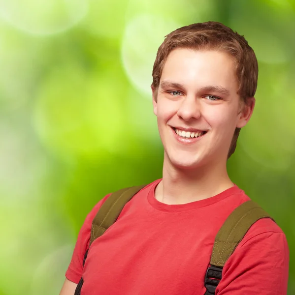 Retrato del joven estudiante sonriendo y usando mochila de nuevo — Foto de Stock