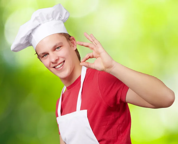 Portret van jonge kok man doen succes symbool tegen een karakter — Stockfoto