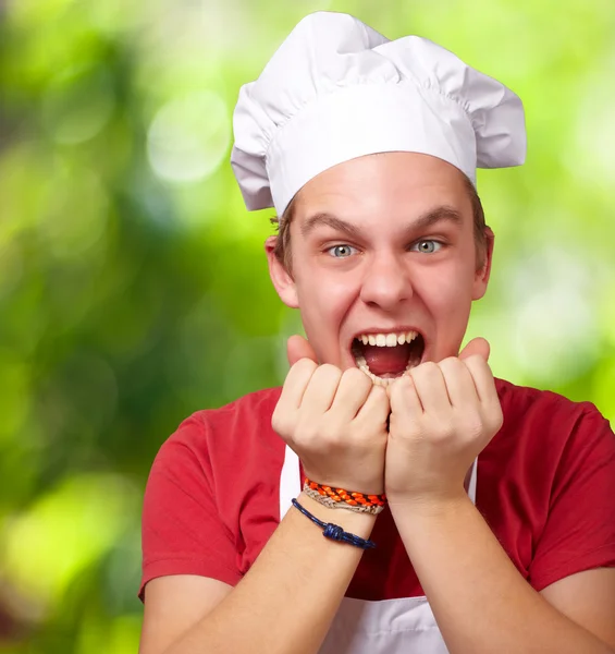 Porträt eines jungen Kochmannes, der vor einem Hintergrund der Natur schreit — Stockfoto