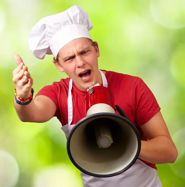 Portrét mladého kuchaře člověka s megafon křičet a gesturin — Stock fotografie