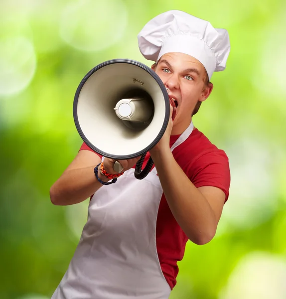 Sikít a megafon ellen egy fiatal szakács férfi portréja — Stock Fotó