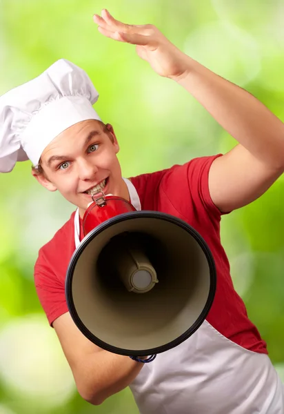 Портрет щасливого кухаря, який кричить за допомогою мегафона на — стокове фото