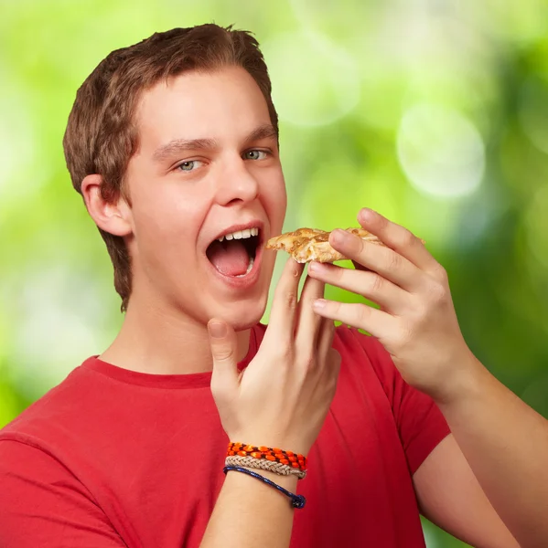 Portré, fiatal ember eszik pizzát a természet háttér — Stock Fotó