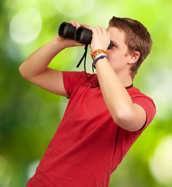 Podobizna mladého muže při pohledu dalekohledem proti nat — Stock fotografie