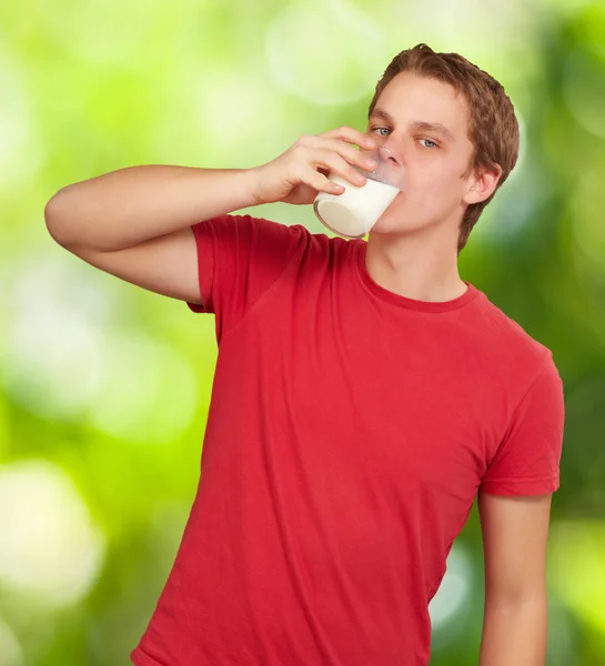 Porträtt av ung man dricka mjölk mot naturen bakgrund — Stockfoto