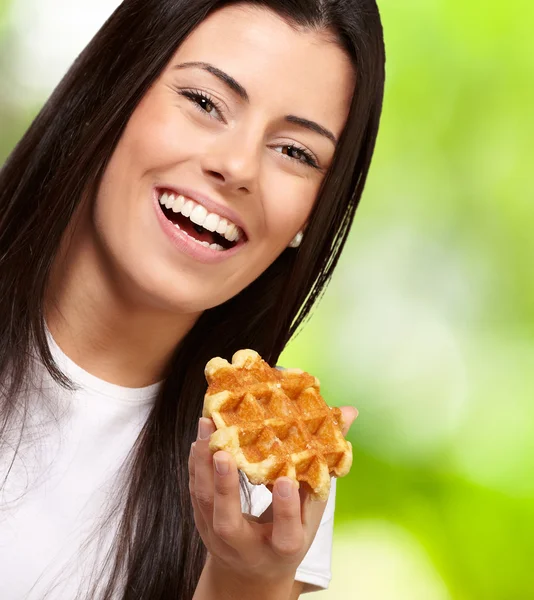 Retrato de mujer joven sosteniendo waffle contra un backgrou de la naturaleza — Foto de Stock