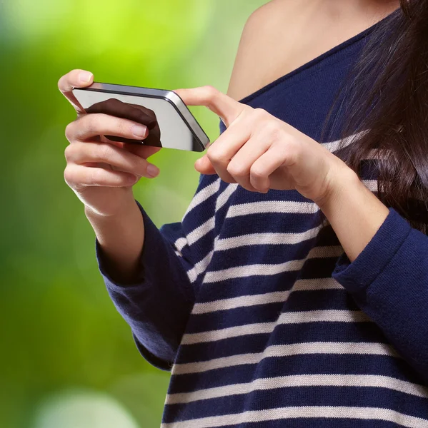 Portret van een jonge vrouw aanraken van een moderne mobiele telefoon tegen een natur — Stockfoto