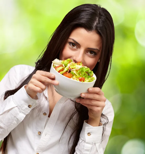 自然 b に対して、新鮮なサラダを保持している若い女性の肖像画 — ストック写真