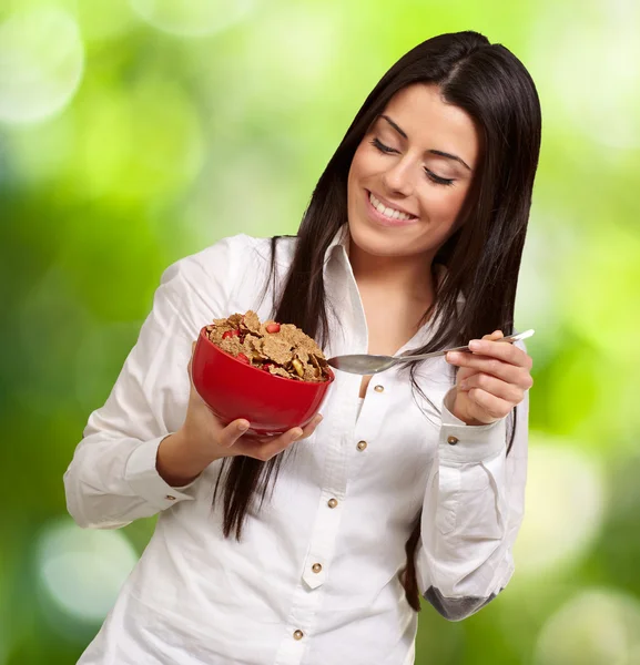 Portrait of healthy young woman eating cereals against a nature — Stock Photo, Image