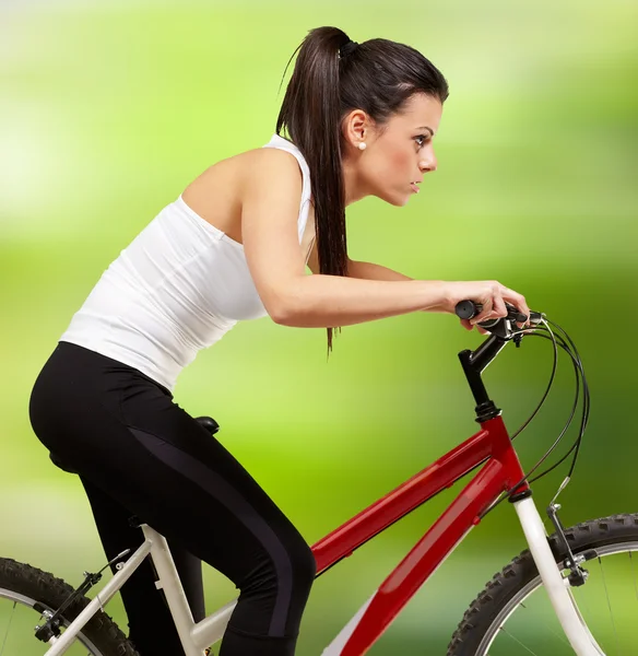 Молодая спортивная девушка на велосипеде на фоне природы — стоковое фото