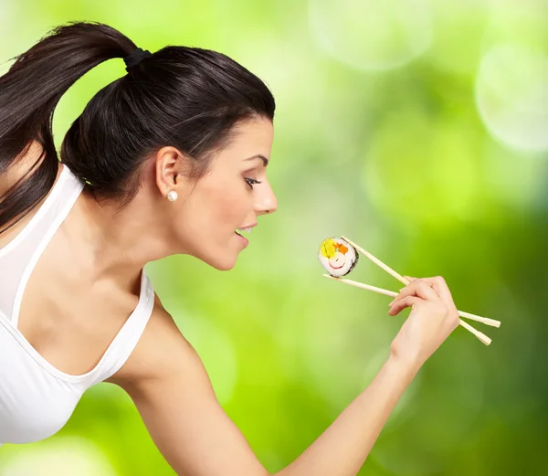 Молодая красивая женщина ест суши на природе — стоковое фото