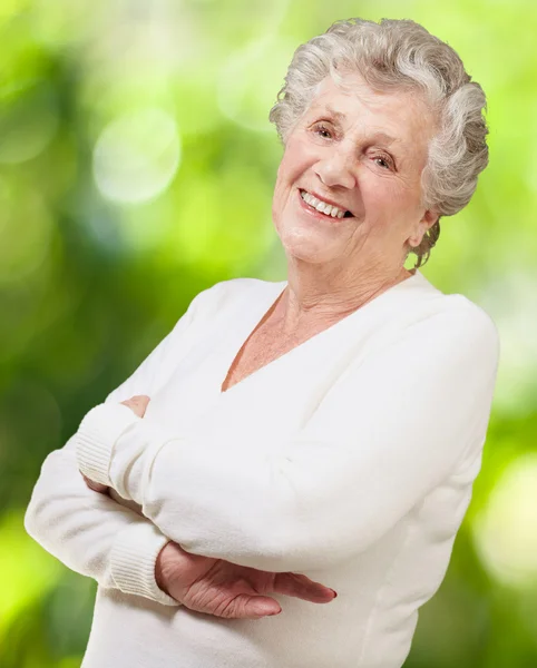 Портрет пожилой женщины, улыбающейся на фоне природы — стоковое фото