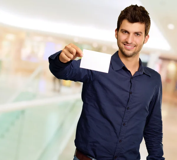 Retrato de un joven sosteniendo una tarjeta blanca en blanco —  Fotos de Stock