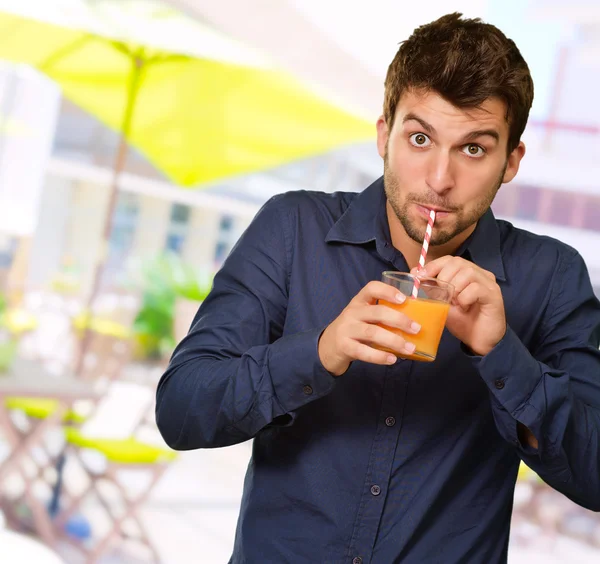 Człowiek popijając sok przez słoma — Zdjęcie stockowe