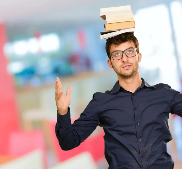 Portrét mladého muže knih na hlavě — Stock fotografie
