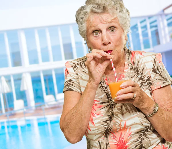 Ritratto di una donna anziana che beve succo — Foto Stock