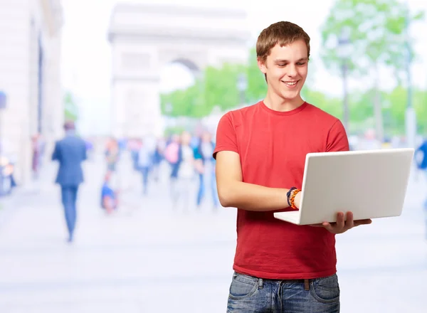 Retrato de homem jovem usando laptop — Fotografia de Stock