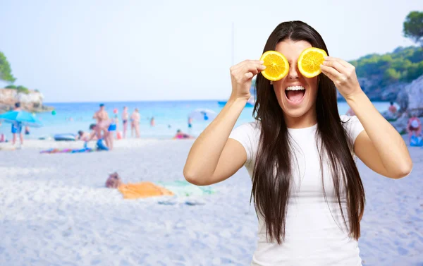 Mulher em uma praia cobrindo os olhos com limão — Fotografia de Stock