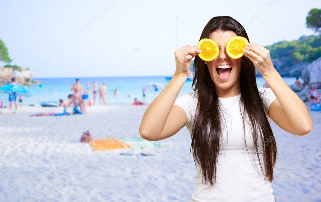 Woman On A Beach Covering Eyes With Lemon