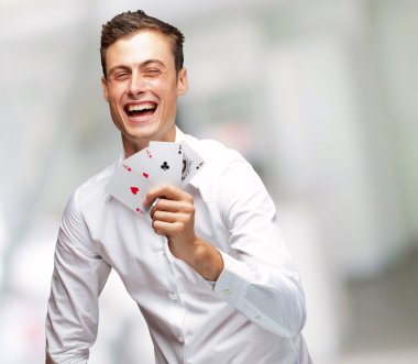 poker kartları gösterilen genç adam portresi